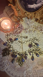 Halskette mit Weinlaub und Lampwork-Himbeeren auf antikem Brief
