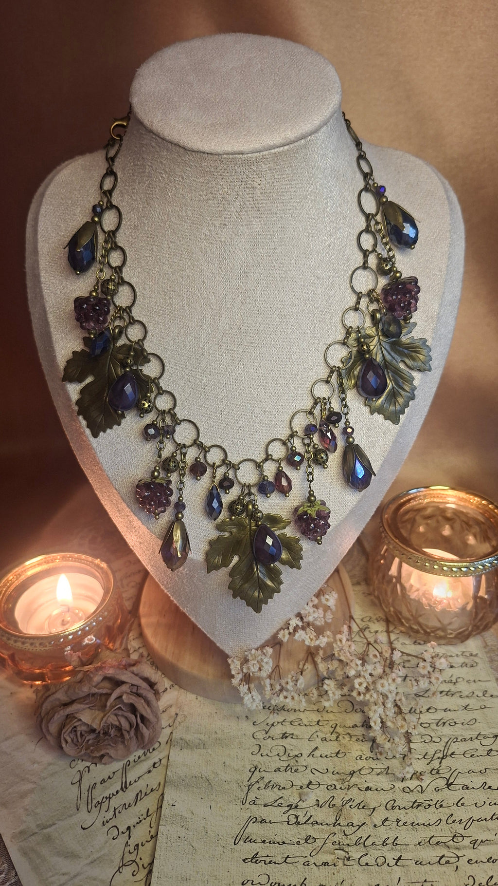 Halskette mit Weinlaub, violetten Lampwork-Himbeeren und blauen Kristalltropfen auf Schmuckbüste