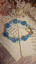 Armband mit dunkelblauen Lampwork-Blütenperlen und himmelblauen Glasperlen auf antikem Brief