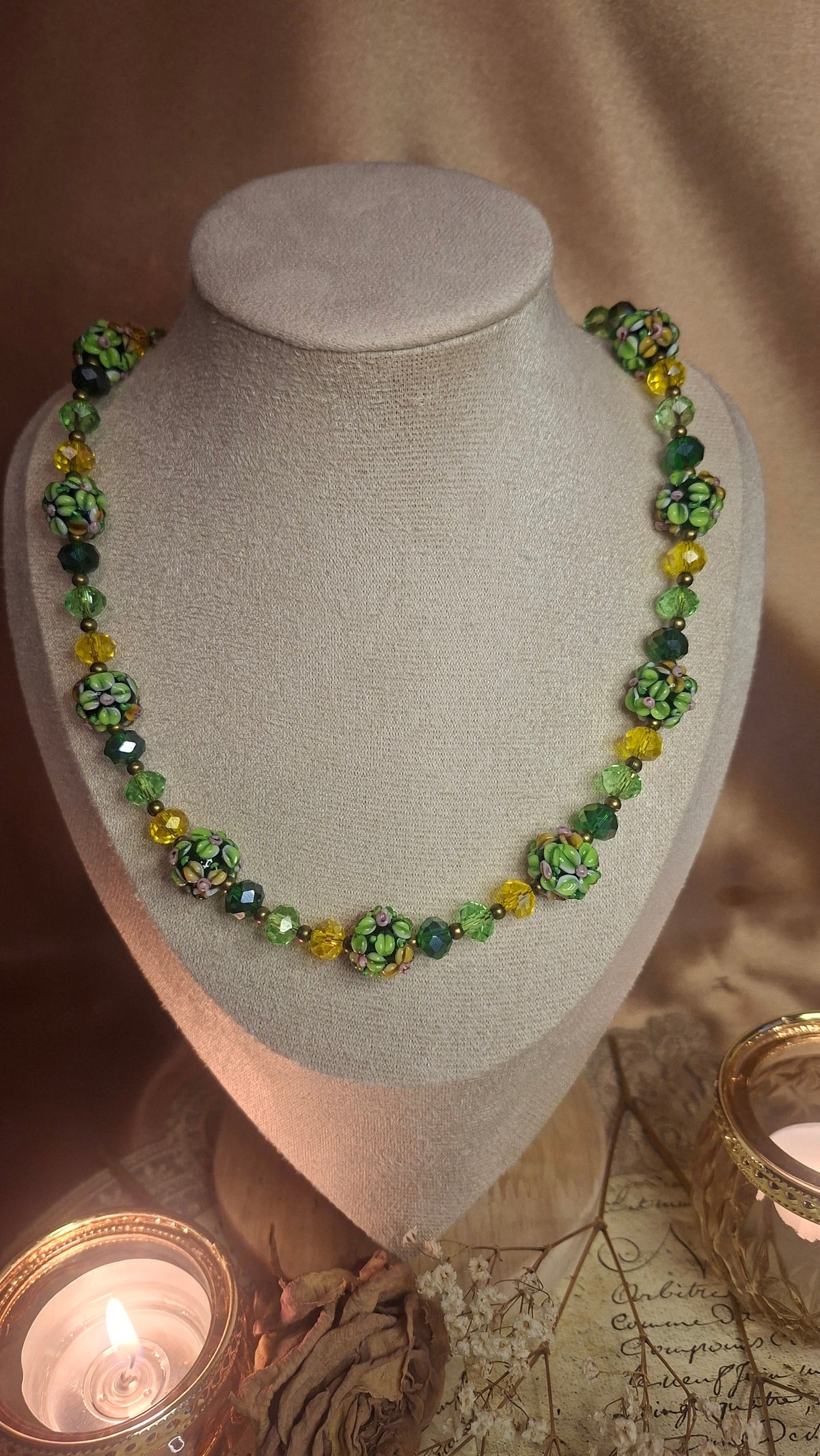Halskette mit grünen Lampwork-Blütenperlen auf Schmuckbüste